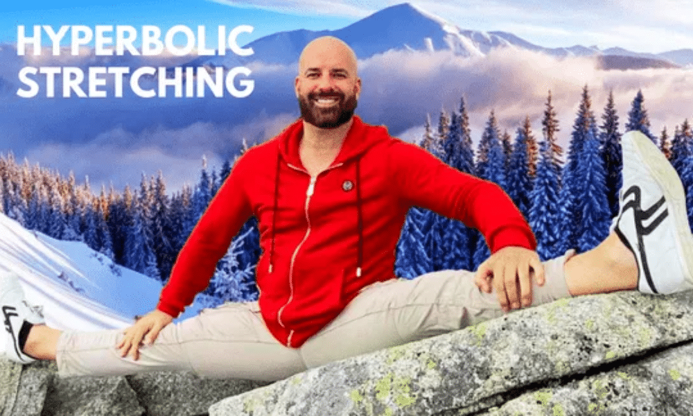 Alex Larsson Peforming the Splits with a winter scene of fir trees and snow-covered mountains in the background